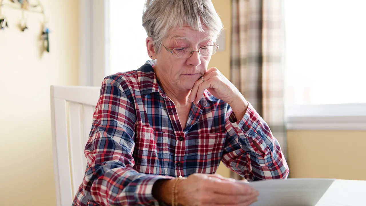 Close up on a plate of mashed potatoes, topped with baked pork chops with cream of mushroom soup, and a side of green beans.